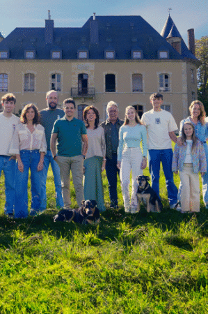 Heel de familie Planckaert buiten op het gras voor hun kasteel in Frankrijk.